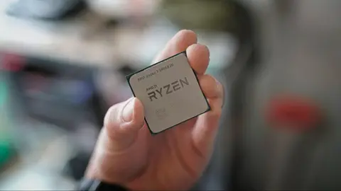 Mão segurando um processador AMD Ryzen 7 5800X3D, com fundo desfocado