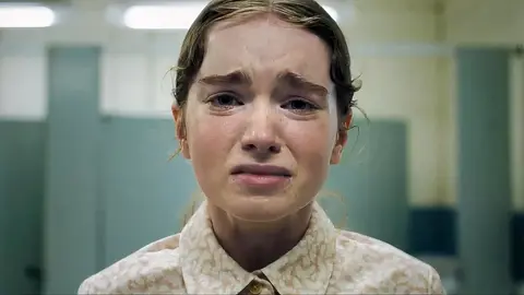 Jovem chorando em banheiro com azulejos verde-claros, cena do filme Carrie