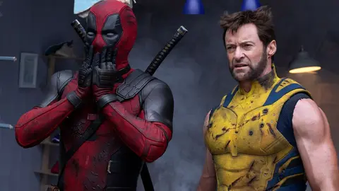 Deadpool e Wolverine em cena do filme: Deadpool com as mãos no rosto e Wolverine de uniforme amarelo ao lado