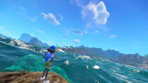 Treinador de boné e mochila azul olha para um mar turquesa com rochedos e costa ao fundo, em cena de jogo estilo Pokémon