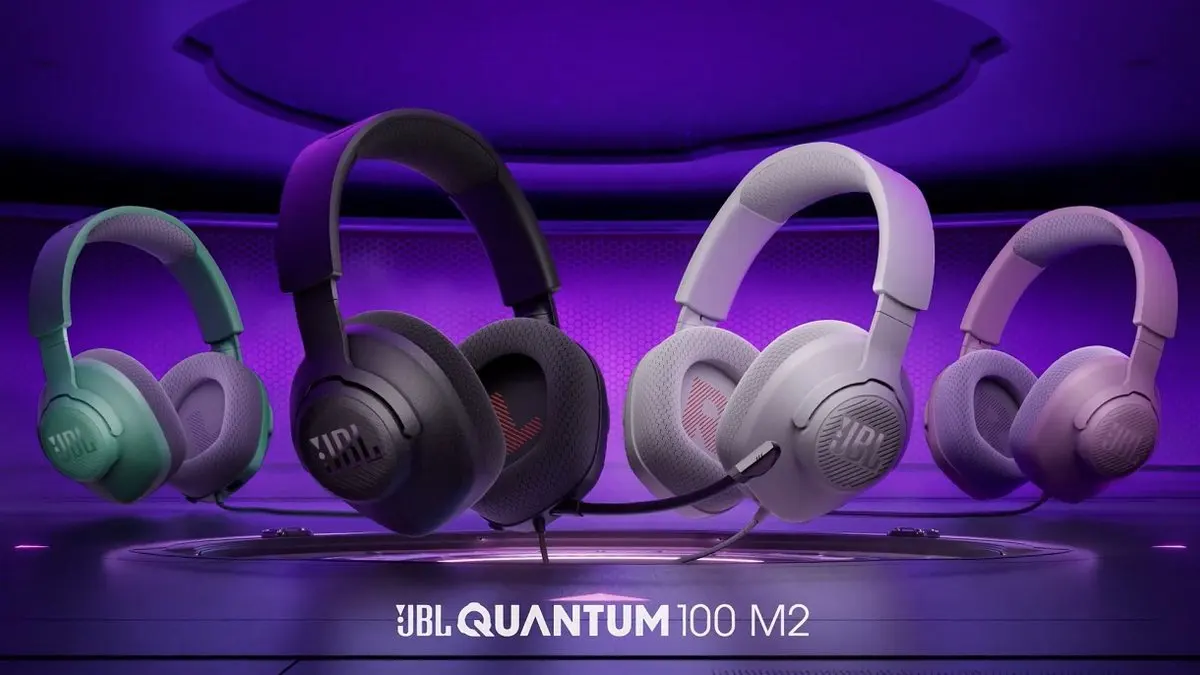 Quatro headsets JBL Quantum 100 M2 em cores diferentes, em plataforma roxa iluminada