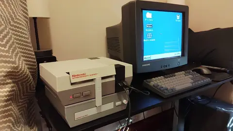 Console NES ligado a monitor CRT Samsung exibindo um desktop estilo Windows, sobre mesa de escritório