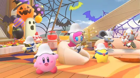 Kirby e outros personagens com chapéus brancos em cenário decorado para Halloween, com abóboras, morcegos e teias de aranha