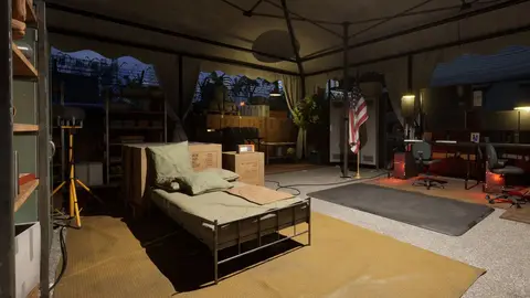 Interior de tenda militar com cama de campanha, caixas de suprimento, bandeira dos EUA e mesa de computador ao fundo
