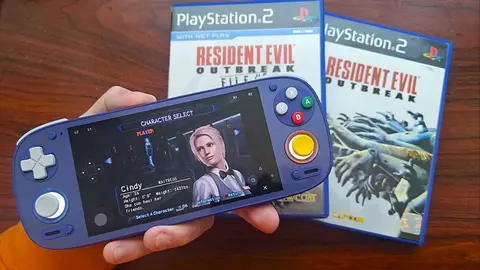 Mão segura um console portátil azul com Resident Evil Outbreak na tela de seleção de personagens, ao lado das capas do jogo para PS2