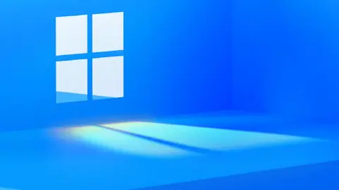 Logo do Windows em janela iluminada numa parede azul, com um feixe de luz no chão
