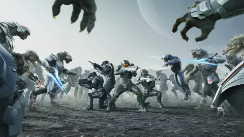 Soldados com armadura verde e cinza enfrentam aliens prateados em campo empoeirado, cena de Halo